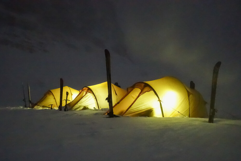 The tents of inspiring explorers glow as they settle in for the night while camping in South Georgia
