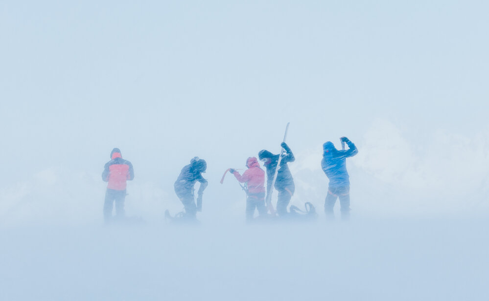 Snow engulfs Inspiring Explorers as they prepare to ski downhill in a snow storm on their South Georgia crossing