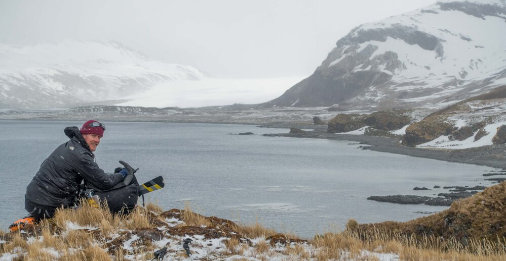 Inspiring Explorer James Blake looking across a bay to a glacier