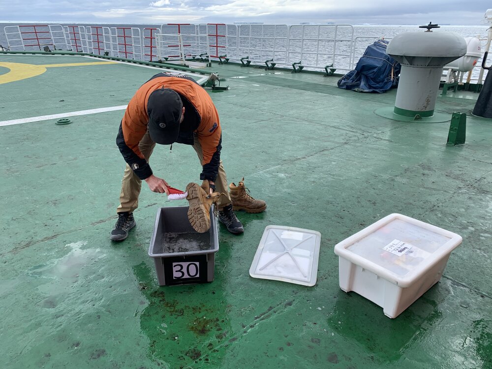 2019-20 Antarctica NZ Representative Johno Leitch cleans his shoes before landing at Cape Adare