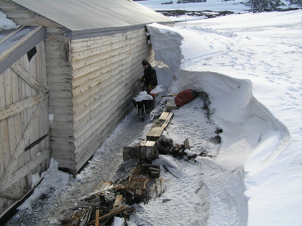 Lead Heritage Carpenter Charley Brentnall removing snow from Scott's 'Terra Nova' Hut
