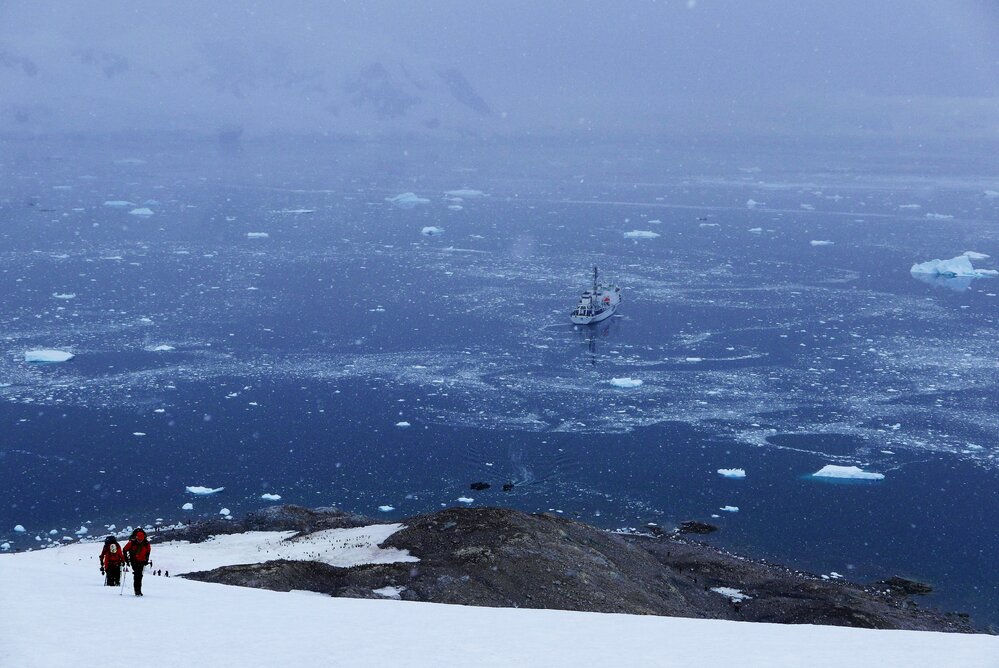 The Inspiring Explorers Expedition&trade; team climbing Pion Peak with the Ship in the background