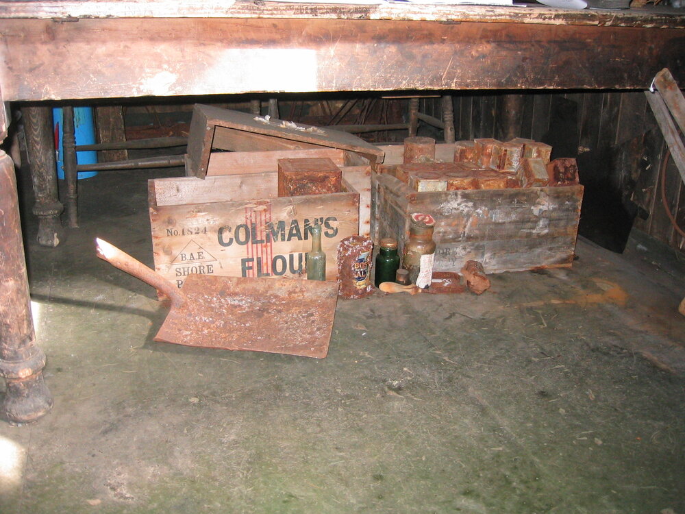 Stores beneath table, mess deck, north west corner in Scott's 'Terra Nova' Hut 