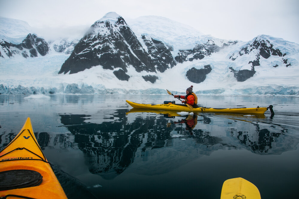 Georgie Archibald kayaking through calm reflective waters