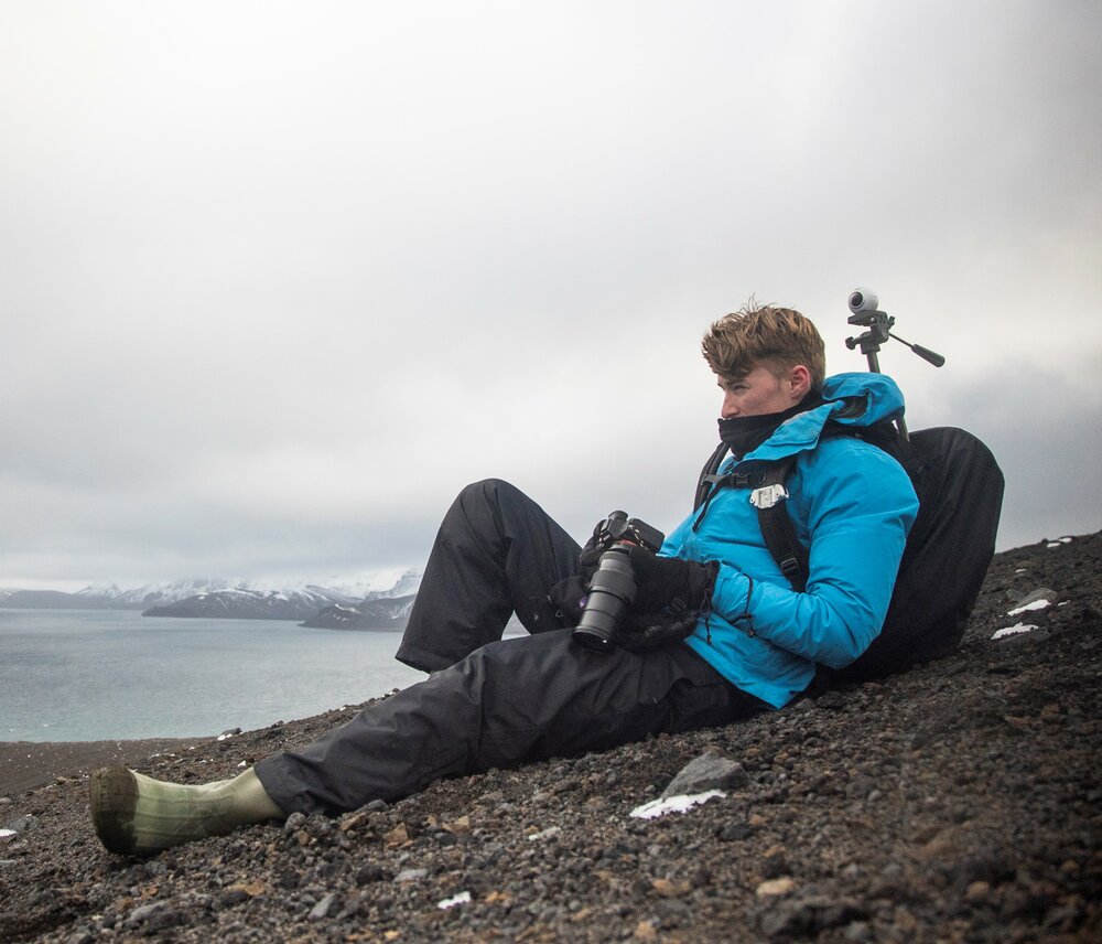 Inspiring Explorer Marco de Kretser with camera gear on Antarctic Peninsula