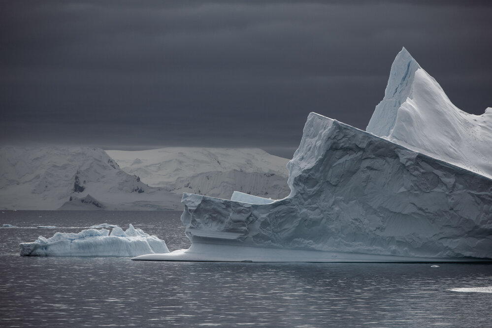 Jagged Antarctic Peninsula ice bergs on calm grey day