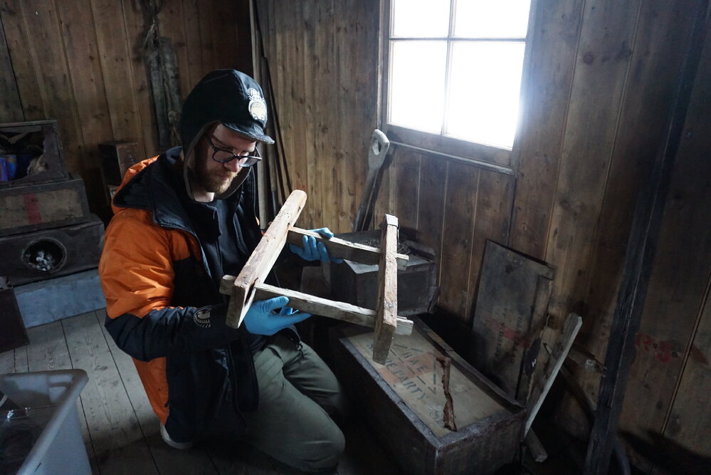 2021-22 Scott's 'Discovery' hut, work task, AHT's Conor Tulloch monitoring artefact