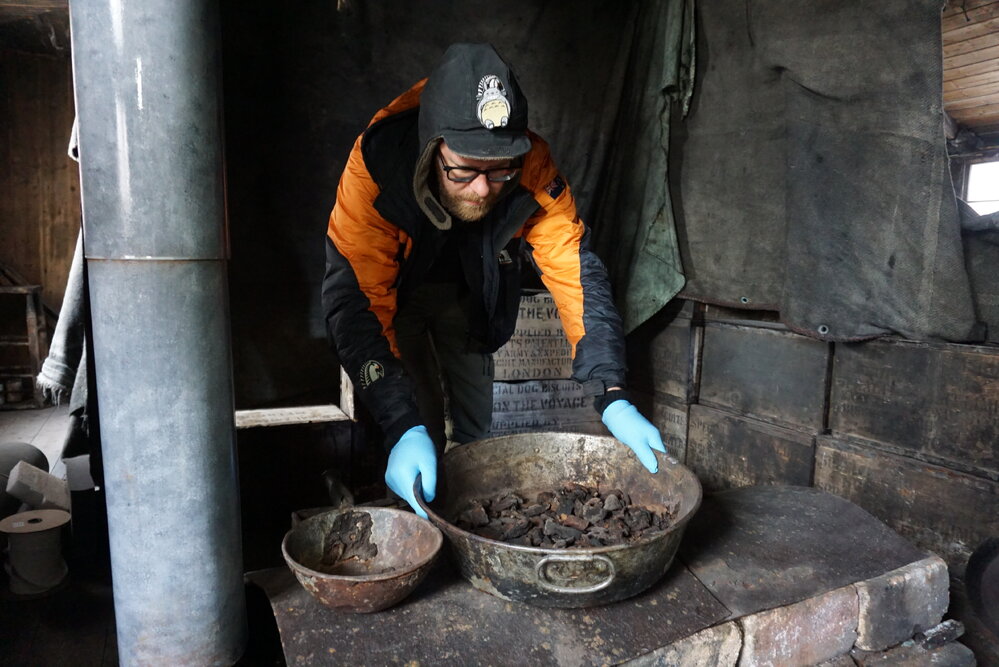 2021-22 Scott's 'Discovery' hut, work task, AHT's Conor Tulloch moving stove top artefact (001)