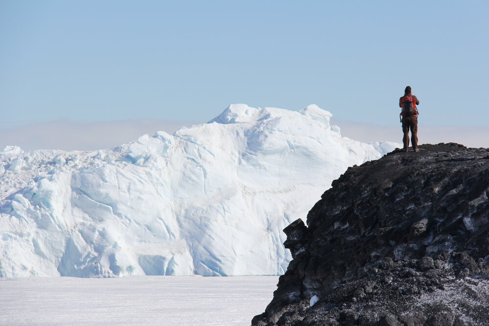 2021-22 AHT's Zack Bennett photographing an iceberg at Cape Evans