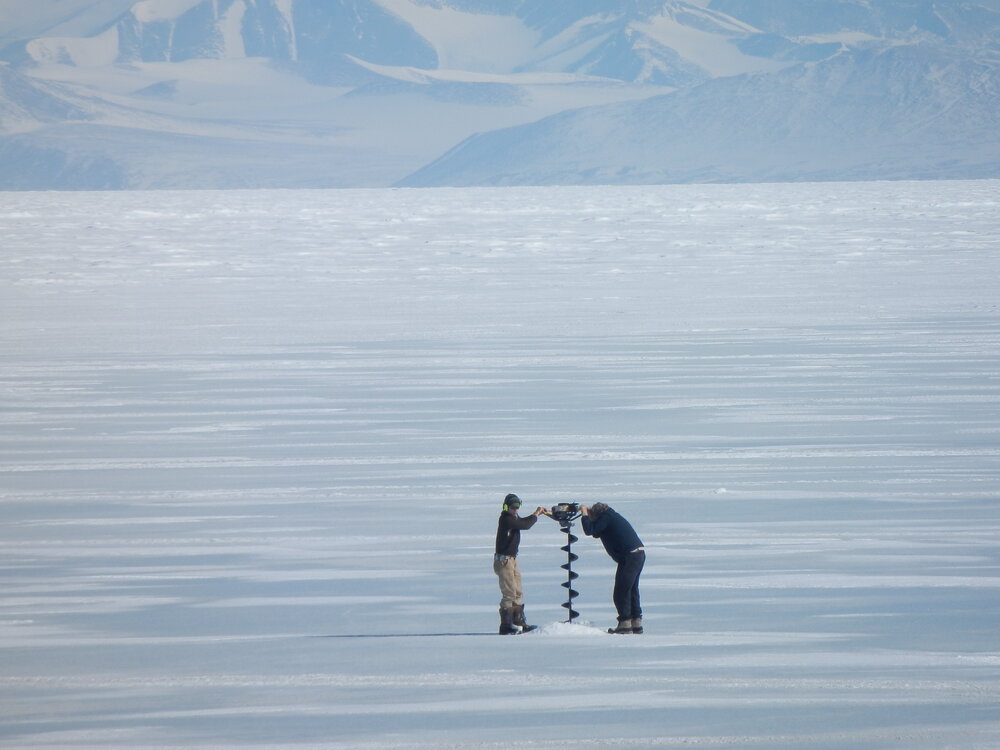 Fish Scientists drilling through ice
