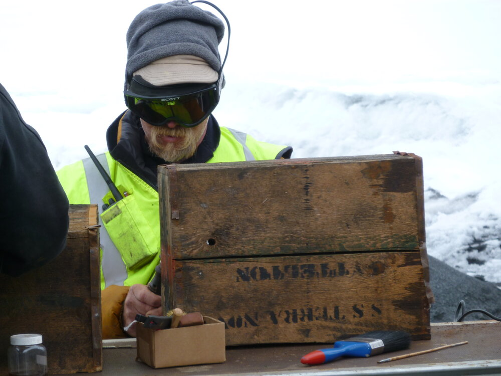 2010-11 Al Fastier treating a timber box outside, Cape Evans