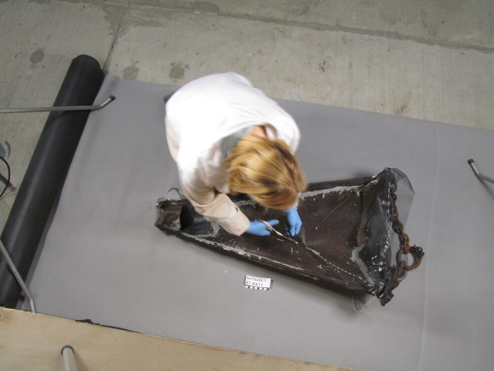 AHT Conservator Julie Unruh cutting away working on dredge