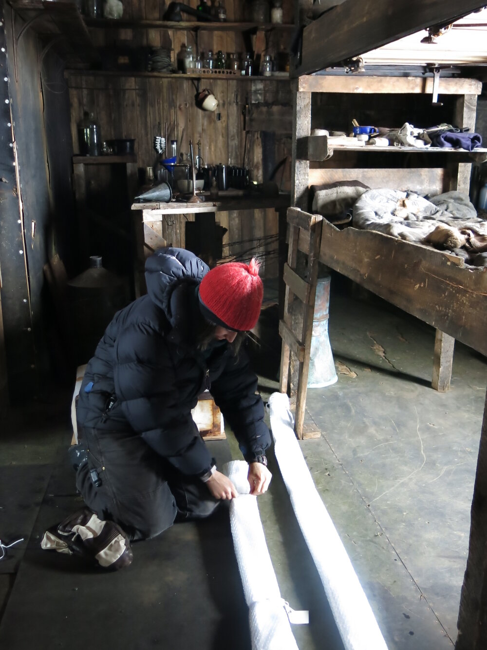 2013-14 Lizzie Meek unwrapping Edward Atkinson's skis, Cape Evans (001)