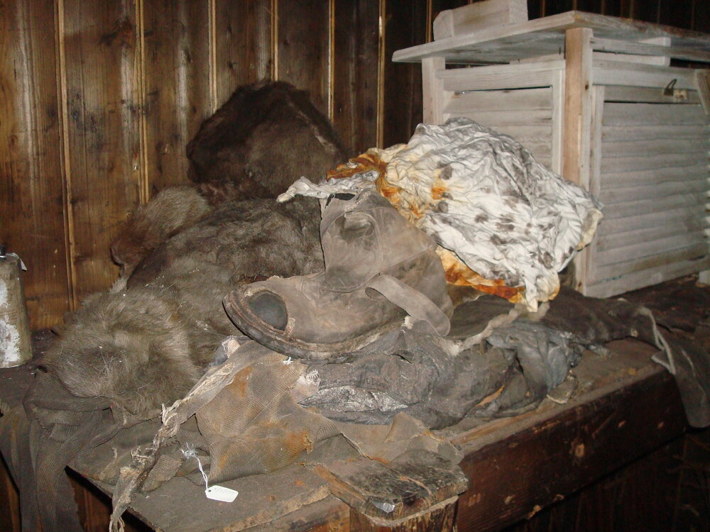 Furs, textiles, boots and Stevenson screen in Messdeck, Scott's 'Terra Nova' Hut
