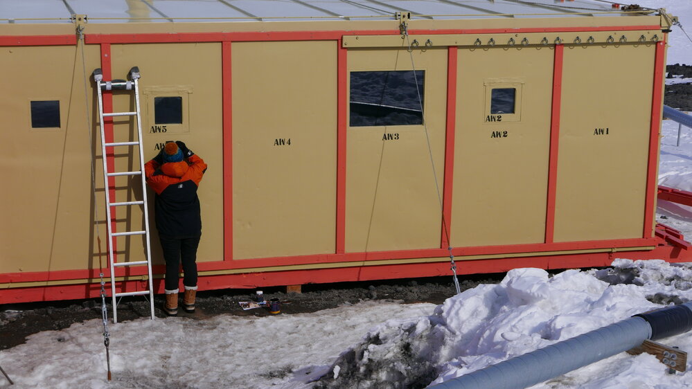 2017-18 Hillary's TAE/IGY hut, work task, AHT's Diana McCormack stencilling exterior wall panels
