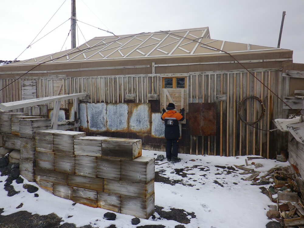 2014 AHT's Nicola Stewart adjusting window shutter on Shackleton's 'Nimrod' hut, Cape Royds