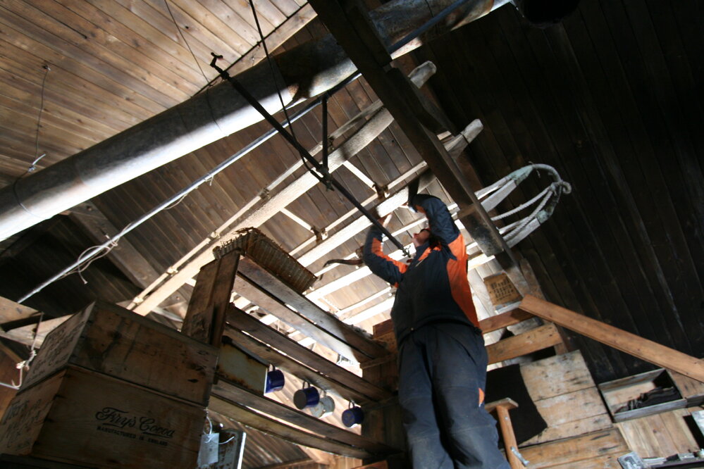 Lizzie Meek working in rafters, Scott's 'Terra Nova' hut 