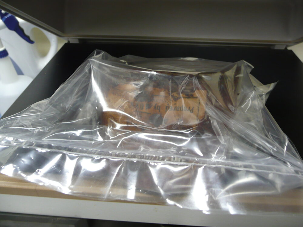Corroded tin being vacuum sealed (003)