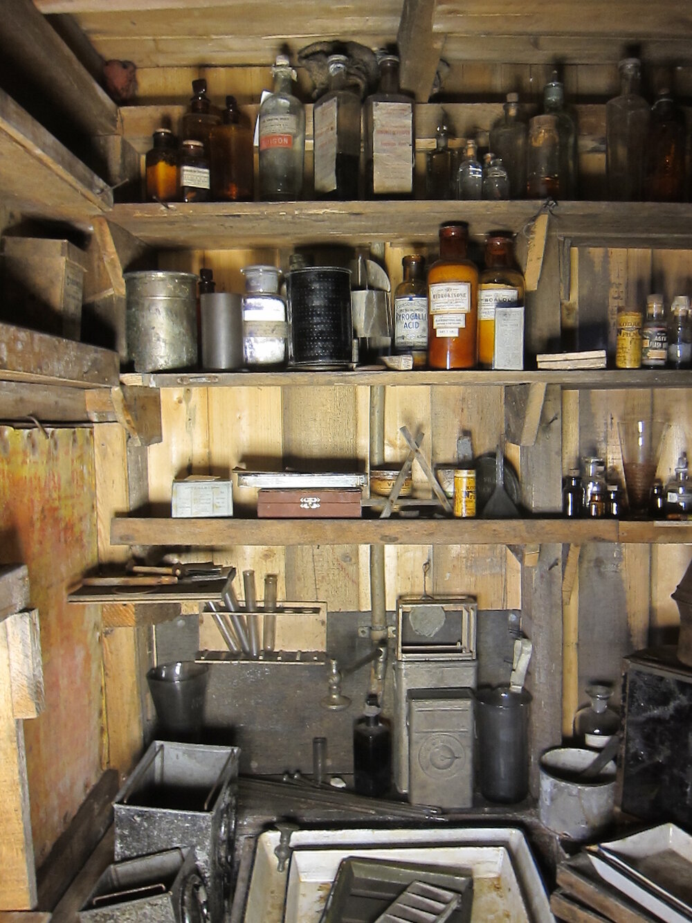 Artefacts on shelves and bench, Darkroom of Scott's 'Terra Nova' hut