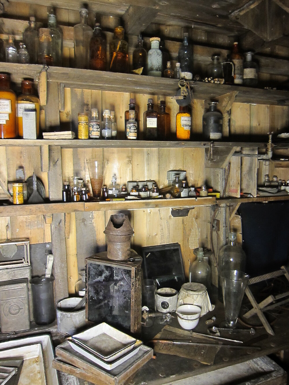 Artefacts on shelves and bench, Darkroom of Scott's 'Terra Nova' hut (001)