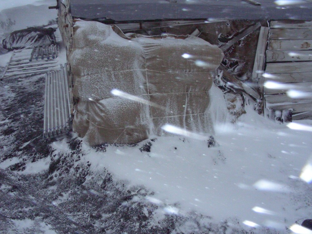 Fodder bales and stable wall during weather event
