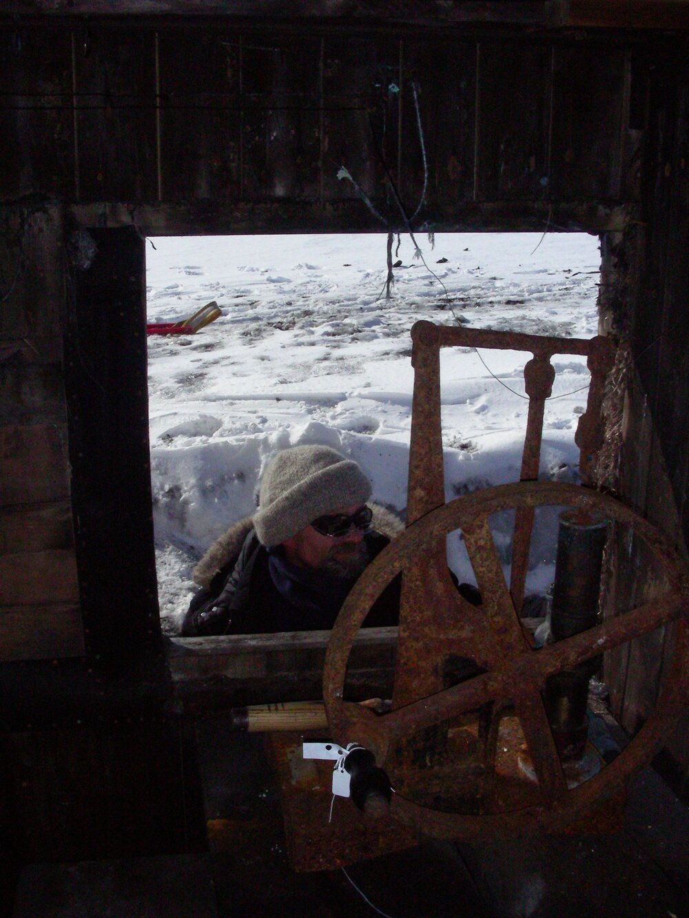 Heritage Carpenter Charley Brentnall looking through removed window, Cape Evans