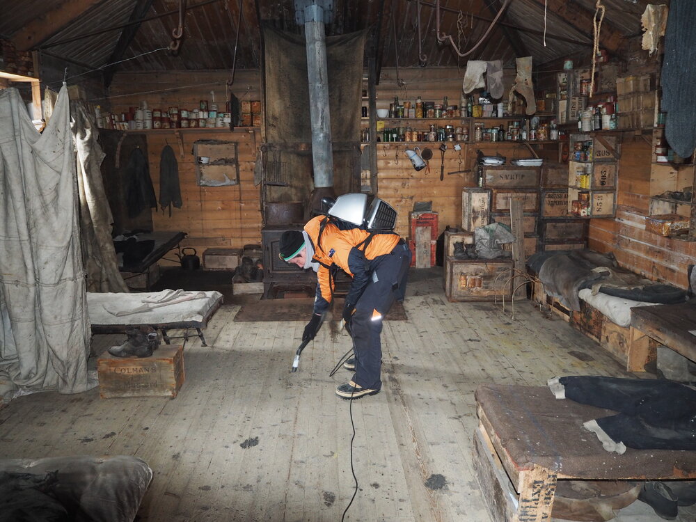Sue Bassett vacuuming, Shackleton's 'Nimrod' Hut