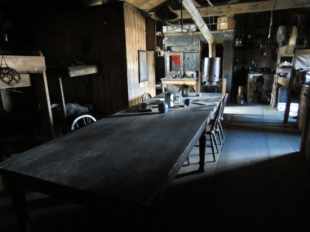 2022 Scott's 'Terra Nova' hut, interior, Wardroom table, looking East