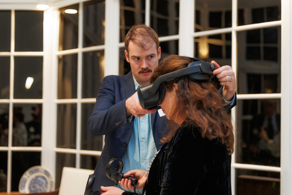 Arek Aspinwall assisting a guest at the launch of the Scott's 'Discovery' hut Virtual Reality Experience