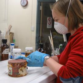 2006 Conservators at work, Nicola Dunn opening a can, Scott Base (001)