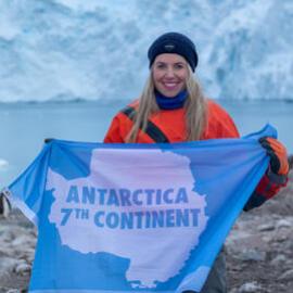 Inspiring Explorer Laurette Siemonek holds up an Antarctic banner