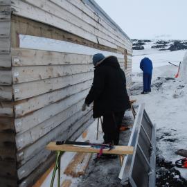Re-installing cladding, Scott's 'Terra Nova' Hut