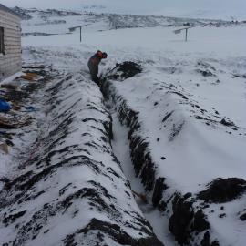 2009-10 AHT's Al Fastier digging trench for deflection dam, Cape Evans