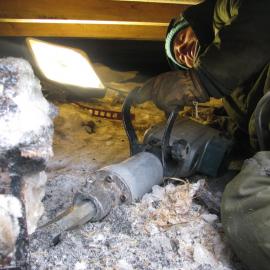 2009-10 AHT Conservator Lucy Skinner excavating alcohol crates underneath Shackleton's 'Nimrod' hut
