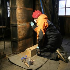 2013-14 Josiah Wagener treating biscuit boxes inside Scott's 'Discovery' hut, Hut Point (002)
