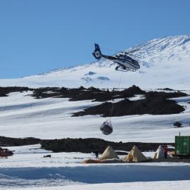 2009-10 Helicopter transporting cargo, Cape Evans field camp