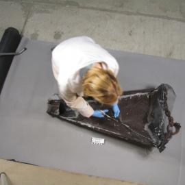 AHT Conservator Julie Unruh cutting away working on dredge