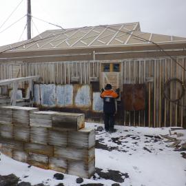 2014 AHT's Nicola Stewart adjusting window shutter on Shackleton's 'Nimrod' hut, Cape Royds