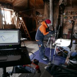 2018-19 Nicola Stewart photographing artefacts inside Shackleton's 'Nimrod' hut