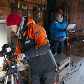 2018-19 Nicola Stewart photographing artefacts inside Shackleton's 'Nimrod' hut