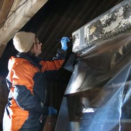 2013-14 Conservators at work. Nicola Dunn treating the water tank, Cape Evans (001)