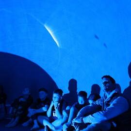 William Pike and Young Inspiring Explorers inside the inflatable planetarium